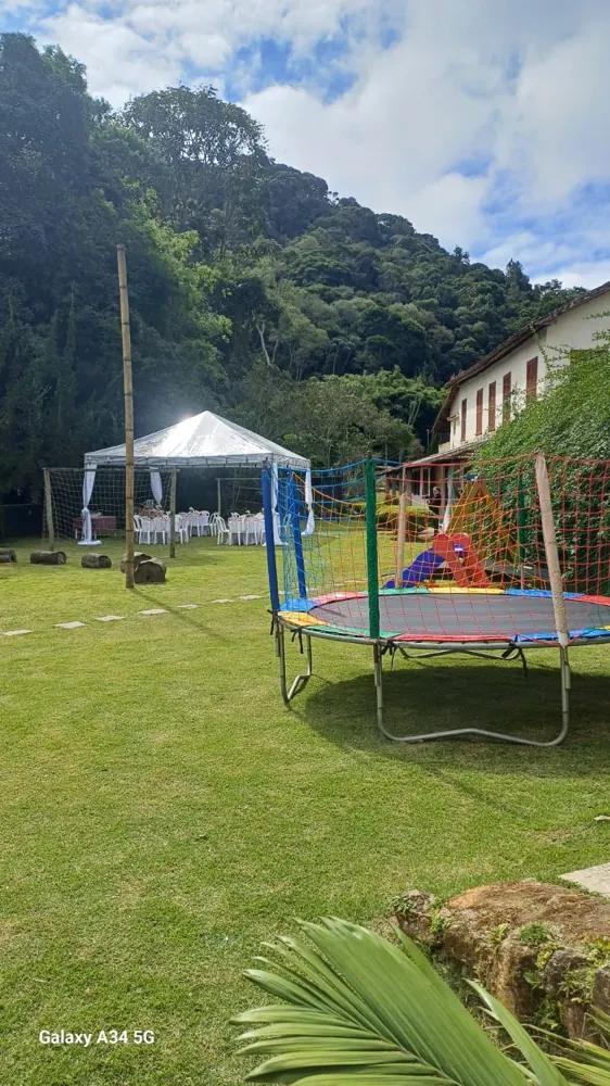 Cama elástica e tenda no gramado da Área 1