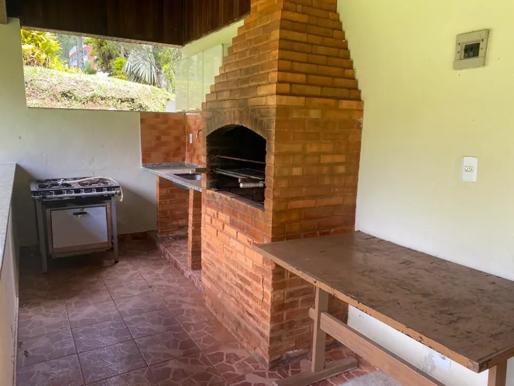 Churrasqueira de tijolos e fogão na área coberta
