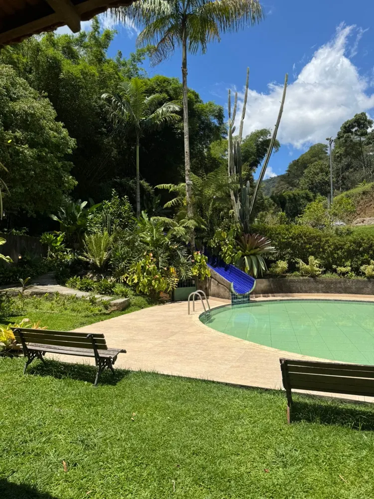 Piscina rasa com escorrega e bancos de madeira