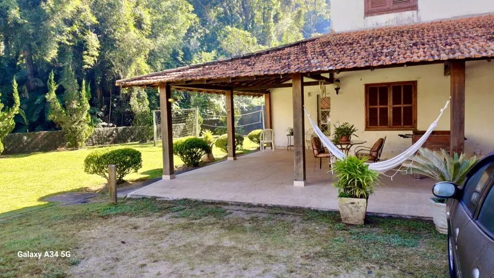 Varanda coberta com rede, em frente ao jardim